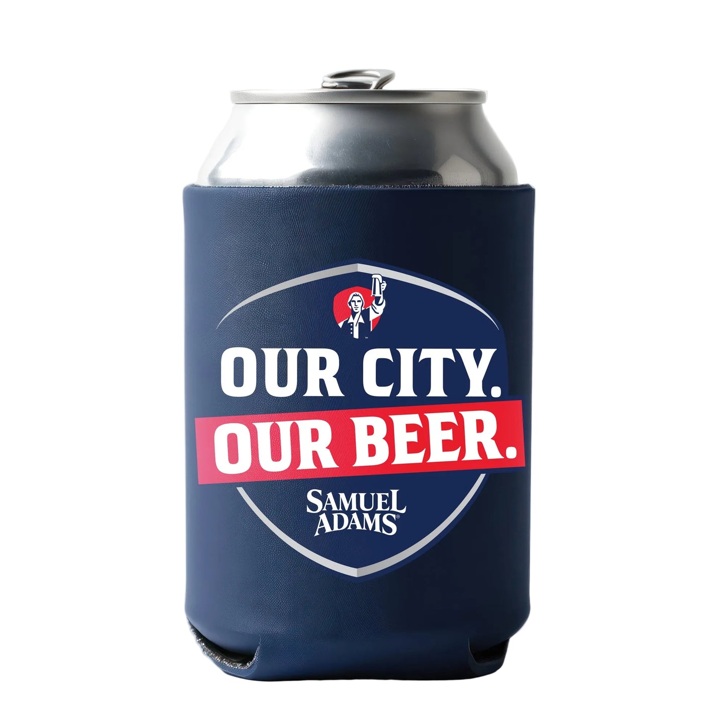 A silver beverage can wrapped in a navy blue can cooler featuring a shield-shaped Samuel Adams design. The shield displays bold white text reading “OUR CITY.” above a red banner with “OUR BEER.” in white letters, along with the Samuel Adams figure icon at the top.