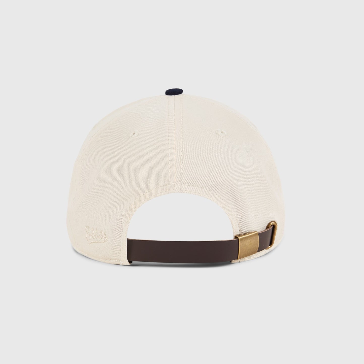 Beige cap with brown and gold strap on a light gray background