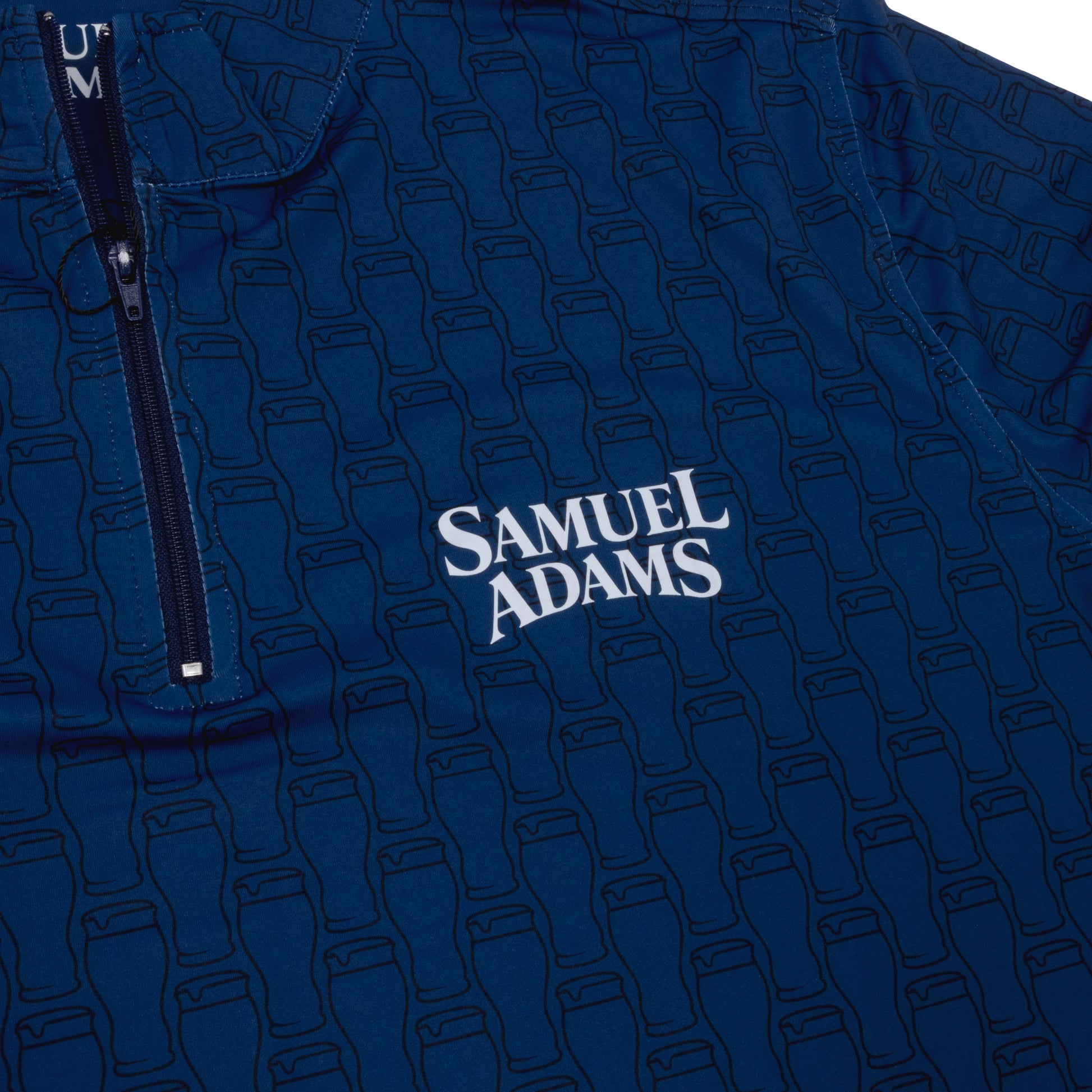 Close-up of Samuel Adams Perfect Pint quarter zip pullover in navy blue featuring subtle pint glass pattern and embroidered Samuel Adams logo on chest