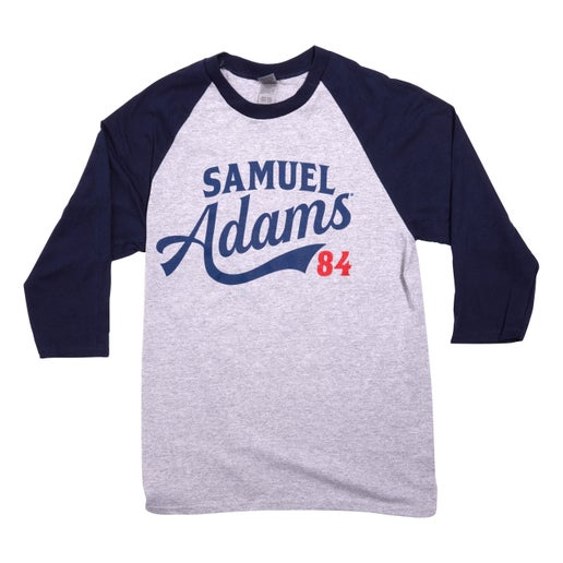 Front of baseball tee has blue sleeves and grey body. On the grey "Samuel Adams" is written in blue and "84" under in red.