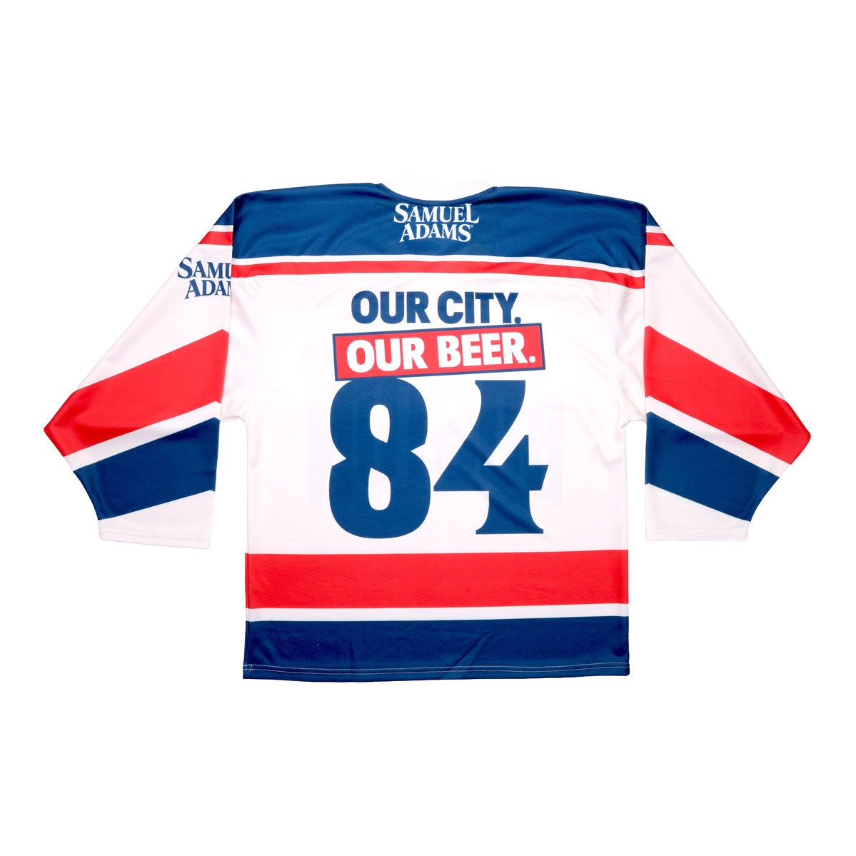 Base of jersey is white with blue and red patterns on the arms, waist, and shoulders. On the blue shoulder panel "Samuel Adams" is written in white. The 'name' on the jersey is "Our City Our Beer" which is written in half blue, half white. And the number on the jersey is 84. The Samuel Adams logo is featured on the left arm in blue.