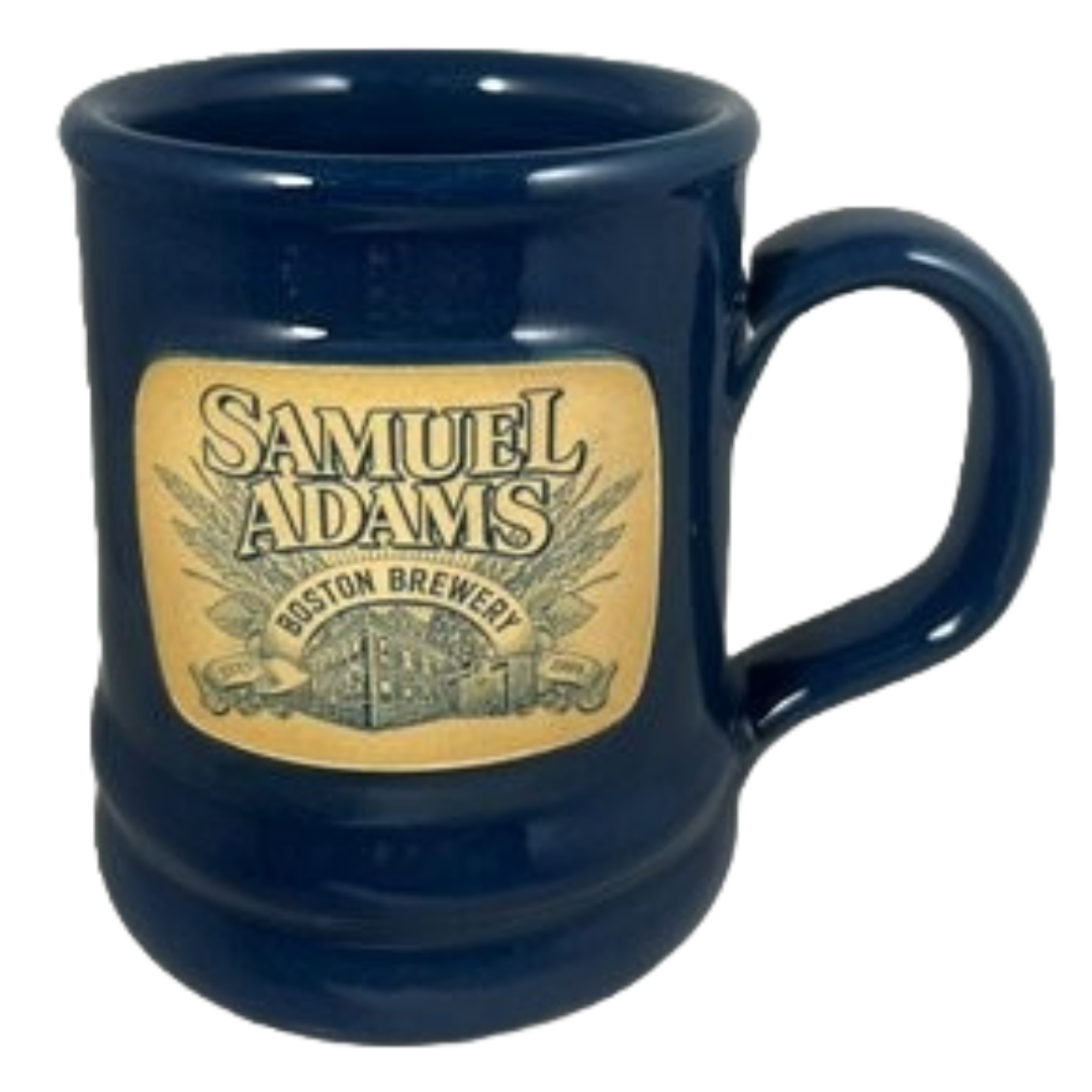 A navy blue ceramic mug with the Samuel Adams Boston Brewery design on the front.