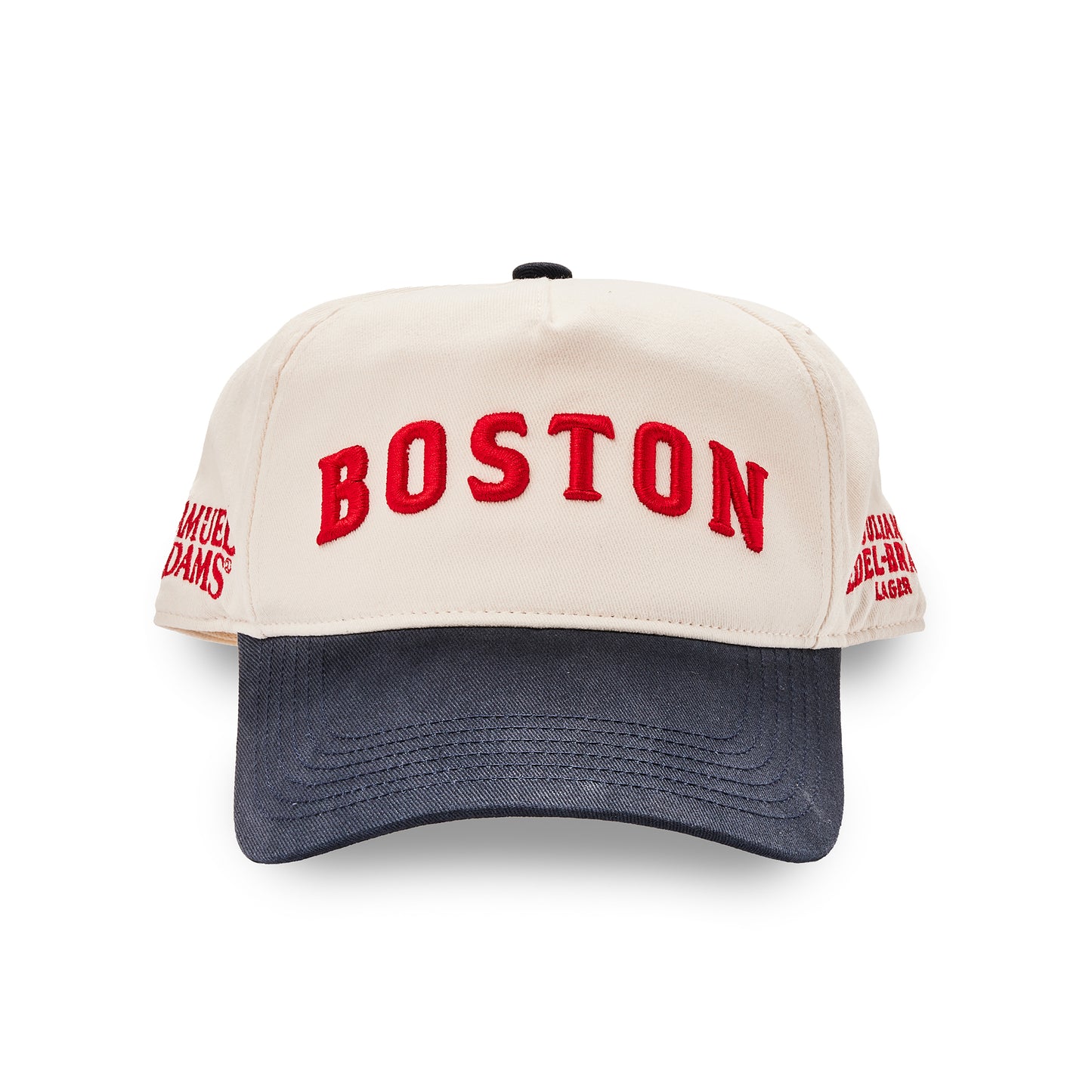 A baseball cap with an off-white crown featuring red embroidered 'BOSTON' text on the front and red side embroidery, paired with a dark navy blue curved brim.