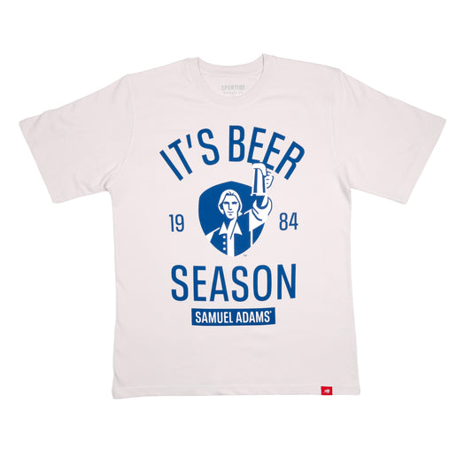 Front view of gray tee features blue writing "It's Beer Season", "Samuel Adams", "1984", and imagery of Sam Adams hoisting a stein on a blue shield background.