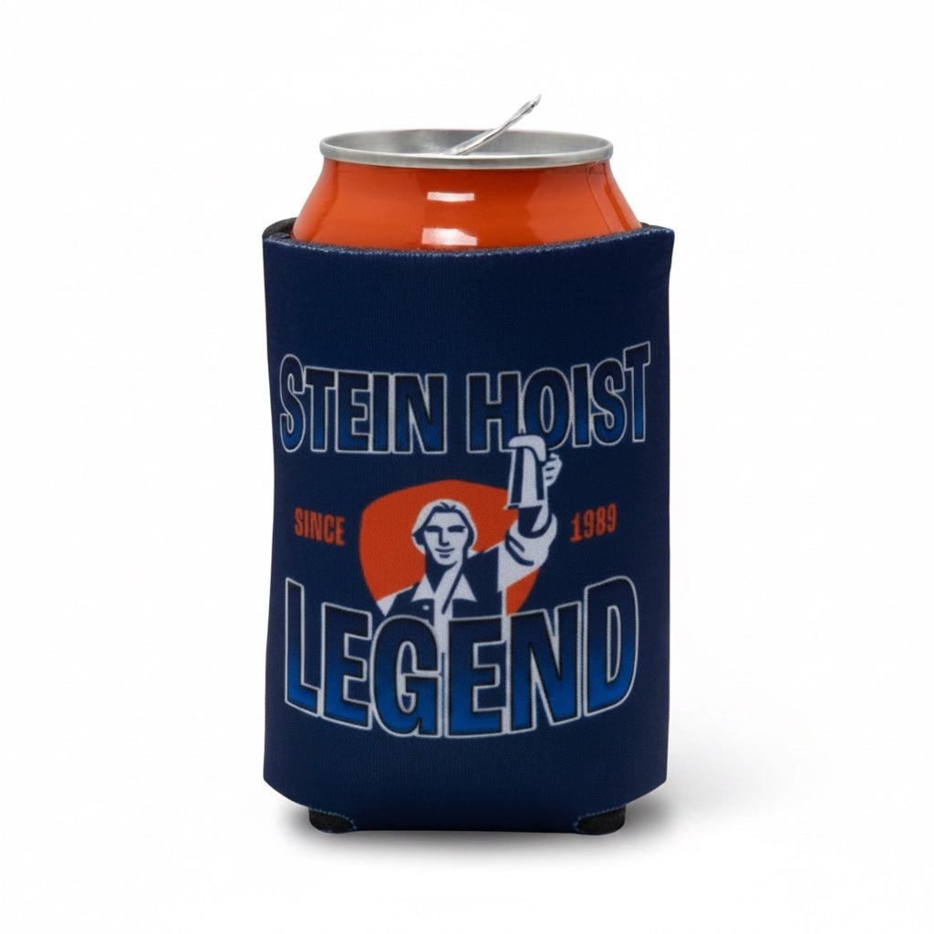 A navy blue neoprene can cooler sleeve holding an orange beverage can, featuring a graphic of a man holding a beer mug with the text 'STEIN HOIST LEGEND' and 'SINCE 1989' on a white background.