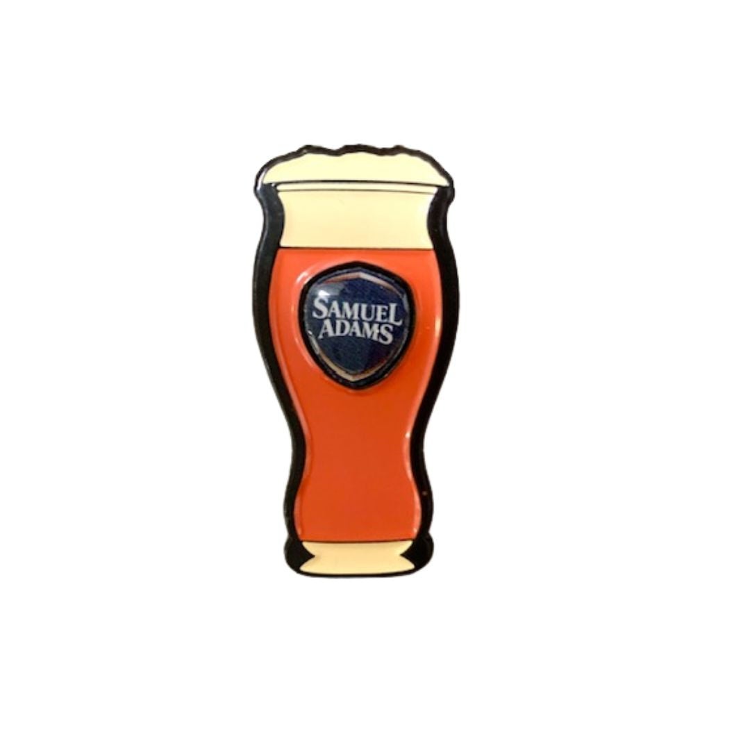A cast alloy metal pin modeled after a perfect pint of Sam Adams beer.
