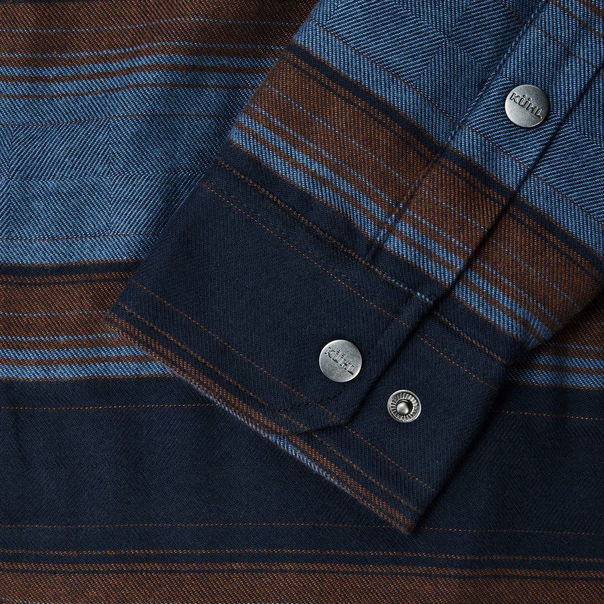 blue and brown striped shirt with silver buttons that say 'kuhl'.