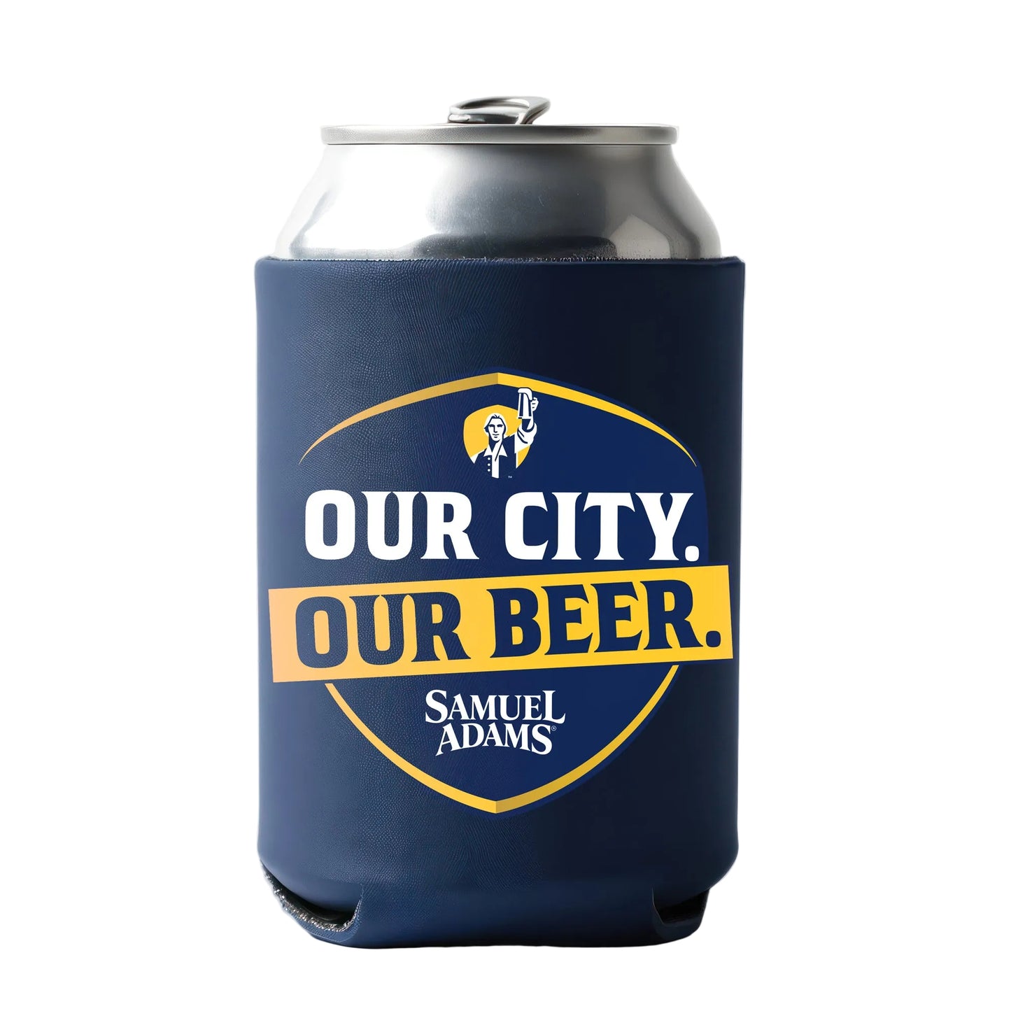 A silver beverage can inside a dark blue can koozie featuring a shield‑shaped design with bold white and yellow text that reads “OUR CITY. OUR BEER.” Above the text is a small illustrated figure raising a drink, and below it is the brand name “Samuel Adams.”