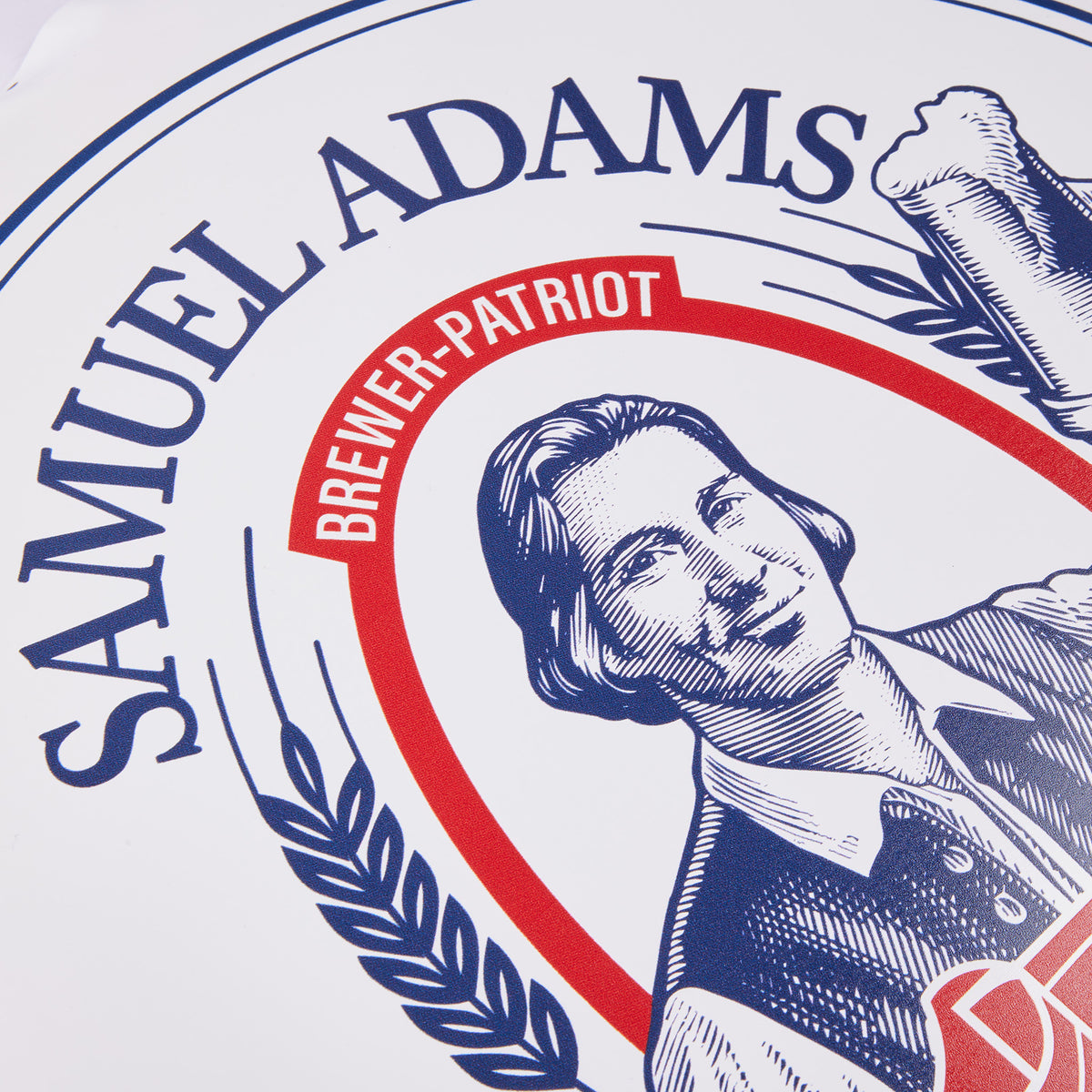 Close up shot of a white wall tacker showing 'samuel adams' with 'brewer-patriot' underneath. 