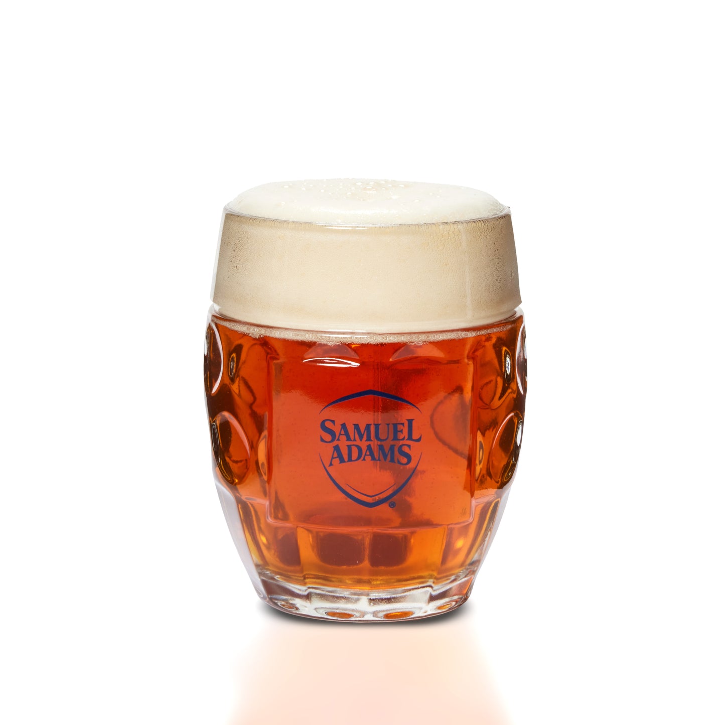 A Samuel Adams beer glass filled with amber beer and topped with a thick white foam head, photographed on a clean white background.