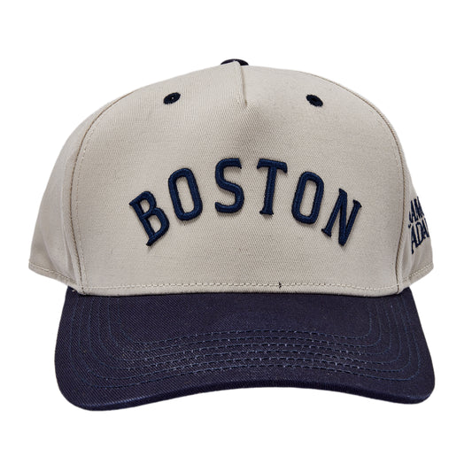 Two tone hat, white cap and navy brim. Raised embroidered Boston text across front.