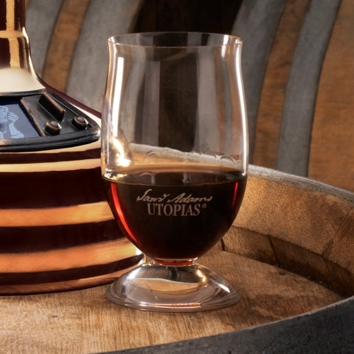 A small-bowled Cognac or snifter glass with the Sam Adams Utopia logo.