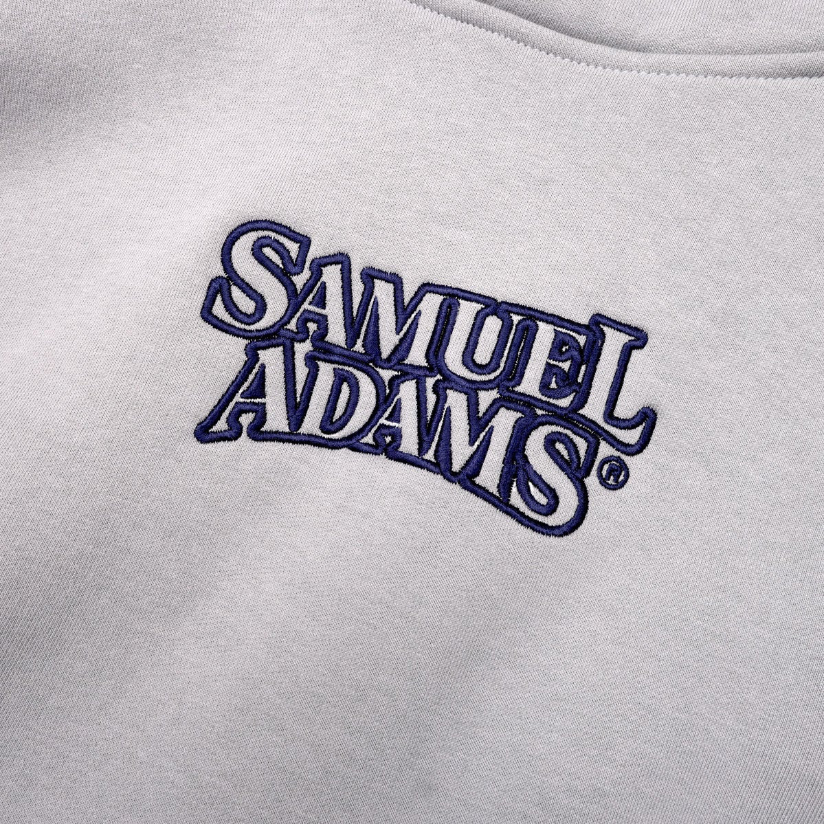 Close up of the Samuel Adams logo on the center of the front of the hoodie.