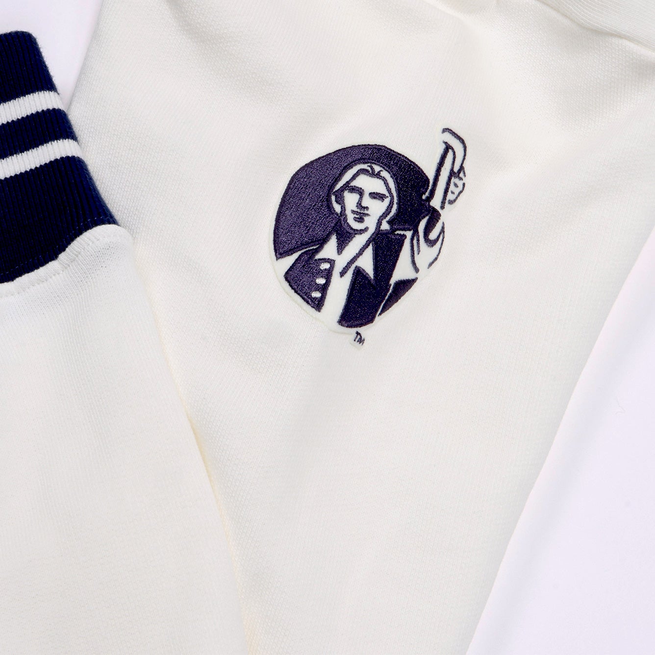 Close up of navy embroidered patch Samuel Adam's logo. Logo shows Samuel Adams cheering with a pint of beer.